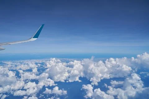 Aerial view seen over clouds, from modern aircraft at daytime. Stock Photos