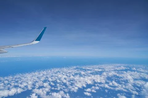 Aerial view seen over clouds, from modern aircraft at daytime. Stock Photos