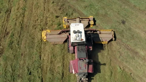 Aerial view of a self propelled mower cutting juicy green grass on a field in 库存影片 136521138