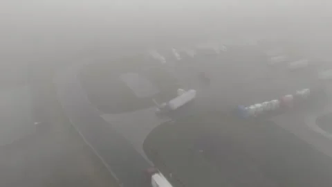 Aerial View of Semi Trucks Navigating Foggy Truck Stop Stock Footage 344782538