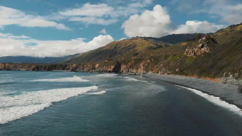 Aerial view of a serene beach between mountains, clear blue waters Stock Footage 309882596