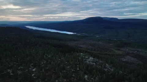 Aerial view of serene lake surrounded by mountains and forests at dusk, Sweden Stock Footage 294983382
