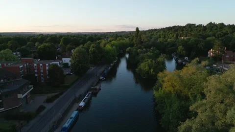An aerial view of a serene river bordered by trees and residential building.. Stock Footage 340516488