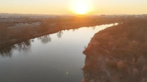 Aerial view of a serene river winding through a city landscape at sunset Stockbeeldmateriaal 335884724