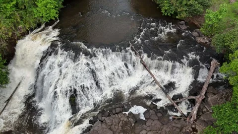 Aerial view of a serene waterfall surrounded by lush greenery and dense forest. Stock Footage 337993618