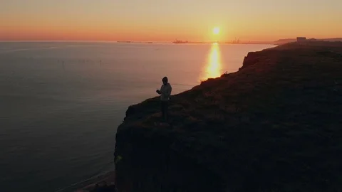 Aerial view serious man operating drone with remote controller outdoors Видео 111950229