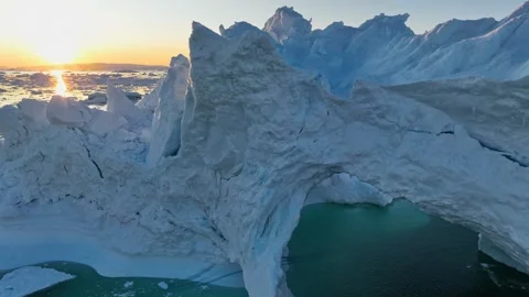 Aerial view of setting sun breaks through the ledges of iceberg. Iceberg with Video stock 246798841
