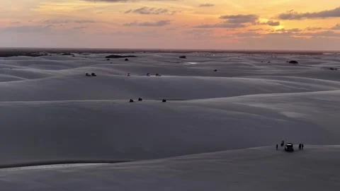 Aerial View of Several ATVs Crossing Ridged Dunes at Sunset Stock Footage 342443936
