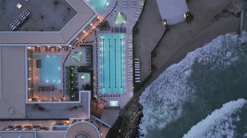 Aerial view of several pools in the spa center on a sea coast at night Stock Footage 231696495