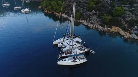 Aerial view. Several sailboats are anchored next to the rocky shore in bay. Stock Footage 98142653