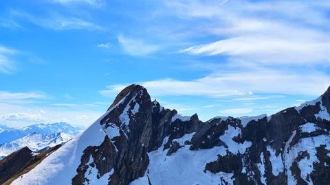 Aerial View of Sharp Alpine Peak with Snow and Blue Sky Fotos de archivo