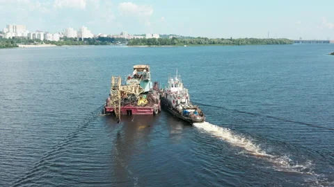 Aerial view. A ship pushes a dredger down a river to a sand Stock Footage 157992234