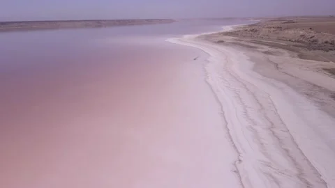 Aerial view of shoreline covered with layer of salt and pink water Stock Footage 195932405