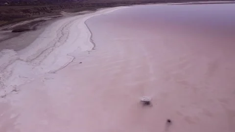 Aerial view of shoreline covered with layer of salt and pink water in Kuialnyk Stock Footage 195932476