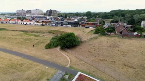 An aerial view showcases a modern triangular building with a green sedum roof Stock Footage 335727902