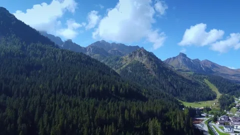 Aerial view showcasing mountainous valley with forest and chalet settlement Video stock 342339646