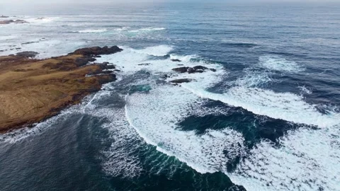An Aerial View Showcasing Ocean Waves Powerfully Crashing Against a Rocky Stock Footage 312513531
