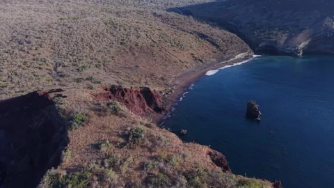 Aerial view showcasing unique red sand beach contrasting with the deep blue Stock Footage 308420736