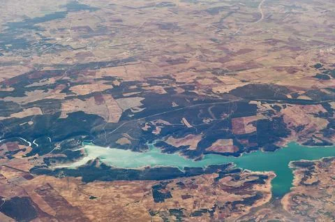 Aerial view showing fields, forests, and a turquoise reservoir of Giribaile.. Stock Photos