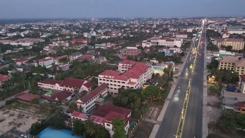 Aerial view shows on both sides of the road, a diverse collection of buildings Vidéo 310215555