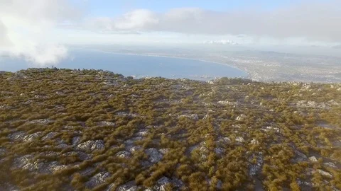 An aerial view shows Cape Town beyond the top of Table Mountain in South Africa. Stock Footage 129443624