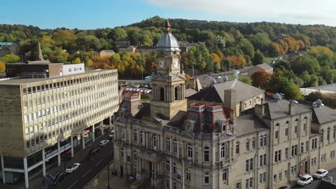 Aerial view shows historic clock tower rising above stone buildings Vidéo 343690216