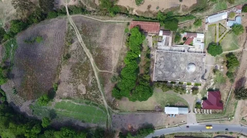 Aerial view shows a mosque with a dome surrounded by fields and buildings in a Stock Footage 313281685