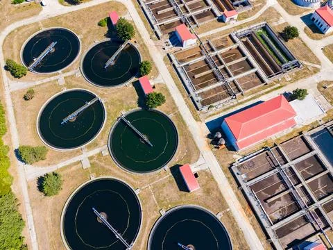 Aerial view shows multiple circular tanks used for water treatment along with Stock Photos