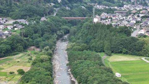Aerial view shows river winding through green hills and villages Stock Footage 340912516