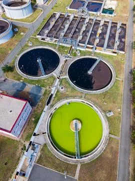 Aerial view shows several circular tanks filled with different colored water. Stock Photos