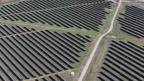 An aerial view shows a vast array of photovoltaic panels arranged in long rows Stock-Footage 334268148