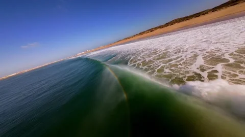 Aerial view shows waves breaking on sandy beach with dunes beyond at Supertubos Video stock 346077285
