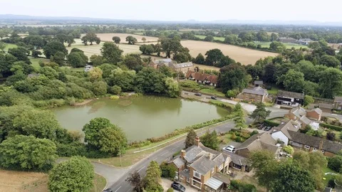 Aerial view, sideways move. Christleton houses next to pond. Village in Chesh Stock Footage 95554338