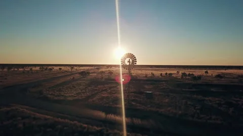 Aerial view. Silhouette of a large windmill in central Australia rotating in slo Stock Footage 294647599