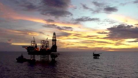 Aerial view of silhouette offshore jack up drilling rig during sunset Stock Footage 238709341