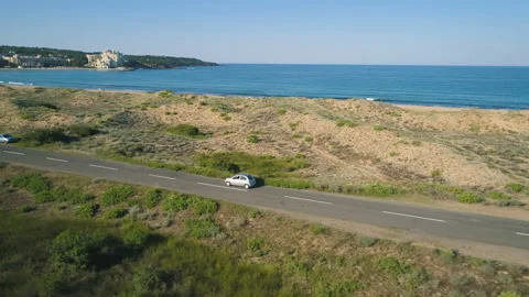 Aerial view of silver car driving at shore line in Alepu, Sozopol, Bulgaria Stock Footage 134774375