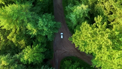 Aerial view of a silver vehicle navigating a winding dirt road through... Stock Footage 341894268
