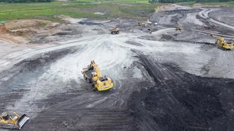 Aerial view of single excavator working on sloped terrain inside coal mining Video stock 329338695