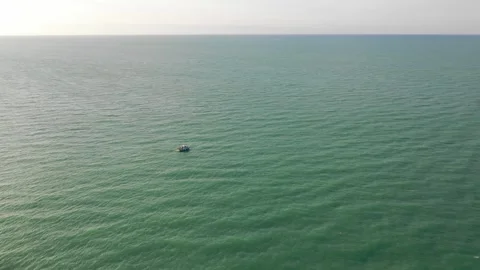 Aerial view of a single small boat floating on the calm, open sea near Saint Stock Footage 346664872