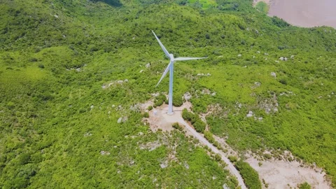 Aerial View of a Single Wind Turbine on a Lush Green Mountain Ridge Stock Footage 342100922