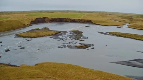 Aerial view of the Skaftá River flowing through a vast, grassy volcanic landscap Stock Footage 320509273