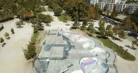 AERIAL VIEW OF SKATE PARK WITH GRAFFITIS FROM A OVERHEAD SHOT TO WIDE ANGLE Stock Footage 102379281