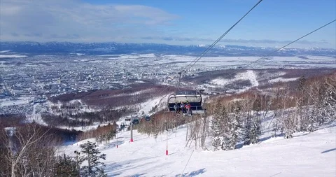 Aerial view of ski lift elevator lifting people on the snowy mountain ski slope Stock Footage 88485753