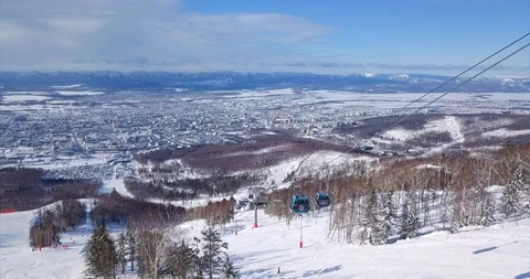 Aerial view of ski lift elevator lifting people on the snowy mountain ski slope Stock Footage 88485755