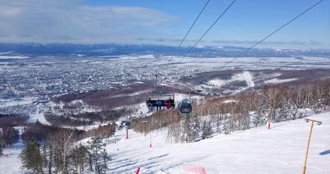 Aerial view of ski lift elevator lifting people on the snowy mountain ski slope Stock Footage 88485764