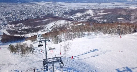 Aerial view of ski lift elevator lifting people on the snowy mountain ski slope Stock Footage 88485827