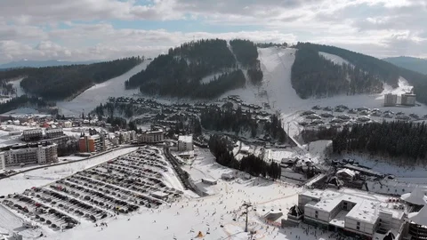 Aerial view of Ski Resort with Ski Slopes and Skiers. Snowy Fir Forest. Bukovel Stock Footage 125944575