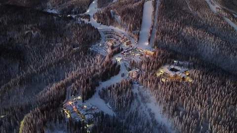 Aerial view of ski resort in winter sunrise or sunset with snowy mountain forest Stock Footage 329480408