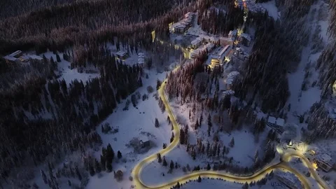 Aerial view of ski resort in winter sunrise or sunset with snowy mountain forest Stock Footage 332874371