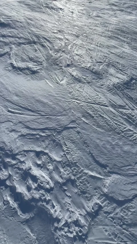 Aerial view of a ski slope with a light blizzard moving powder snow upwards Stock Footage 202250736